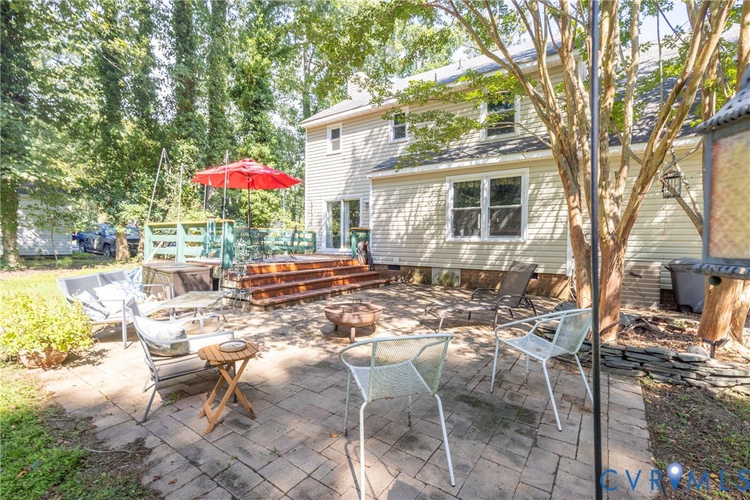 13802 Rockhaven Drive, Thornhill, Chester, VA 23836 Expansive paver patio with a raised wooden deck featuring multiple steps, a privacy fence, and vinyl siding exterior