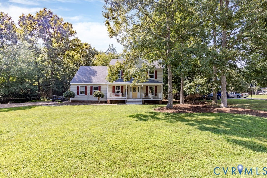 13802 Rockhaven Drive, Thornhill, Chester, VA 23836 Two-story residence with a covered front porch featuring white railings, red window shutters, a light-colored exterior, and an expansive front lawn