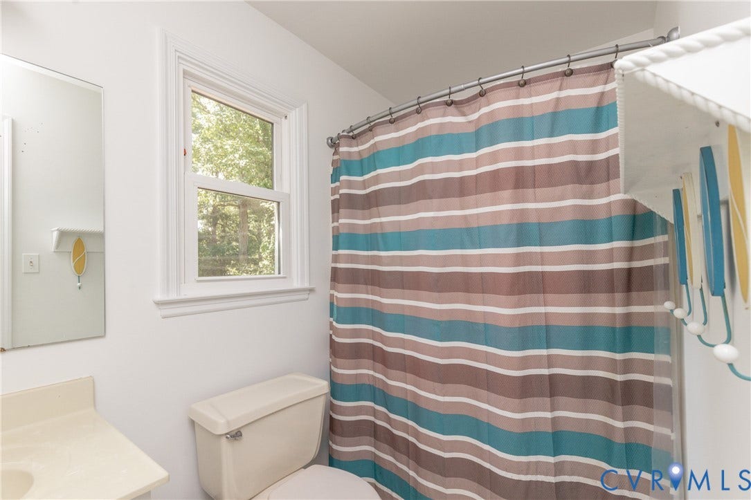 13802 Rockhaven Drive, Thornhill, Chester, VA 23836 Single pane window with white trim, built-in shelving, mirror, and white vanity with a single sink