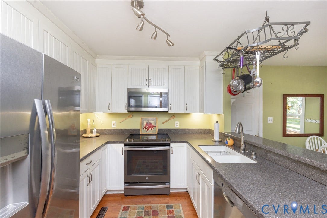 13802 Rockhaven Drive, Thornhill, Chester, VA 23836 U-shaped kitchen with white cabinetry, dark countertops, stainless steel appliances, and a built-in pot rack