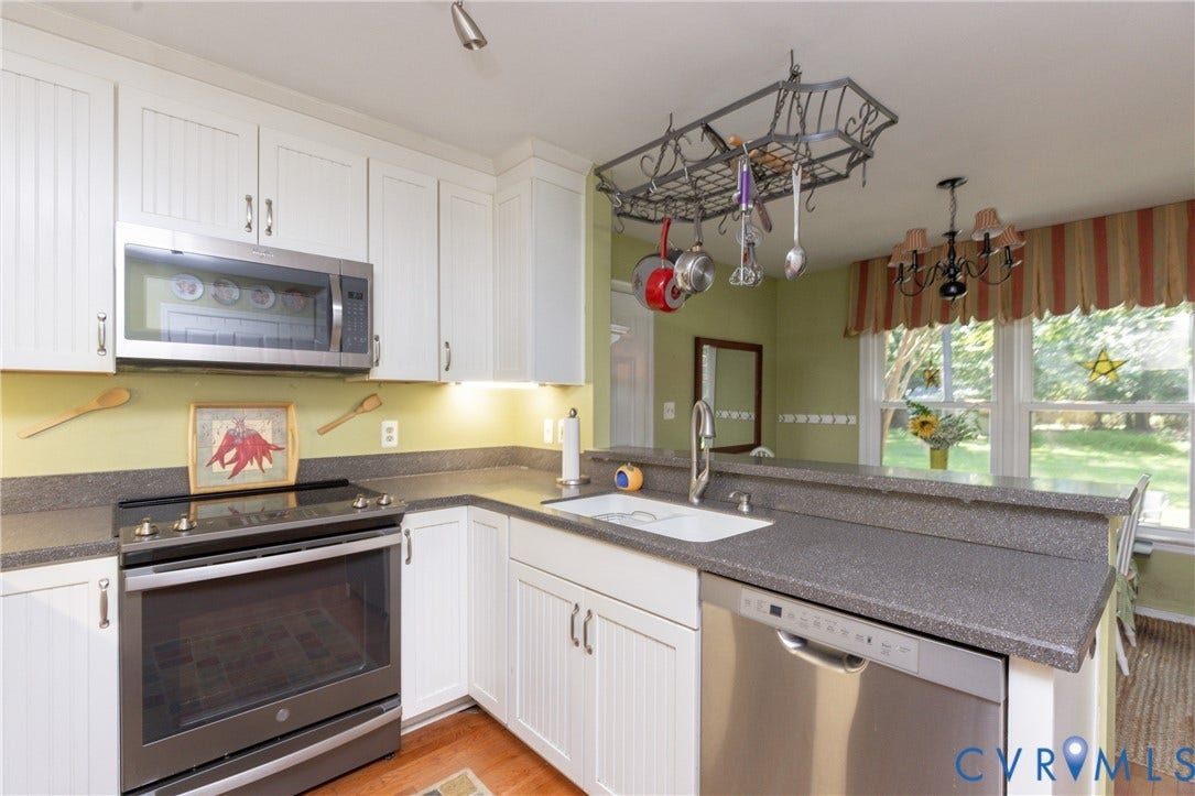 13802 Rockhaven Drive, Thornhill, Chester, VA 23836 White cabinetry, stainless steel appliances, a pot rack, a kitchen sink, and a multi-pane window