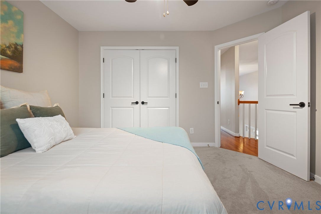 White paneled doors with matte black hardware, neutral wall paint, and plush carpeting