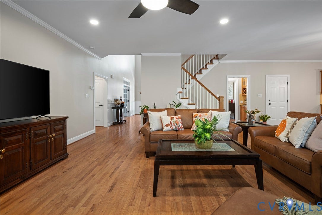 Hardwood flooring, recessed lighting, crown molding, a ceiling fan, and a wood-finish staircase with white risers