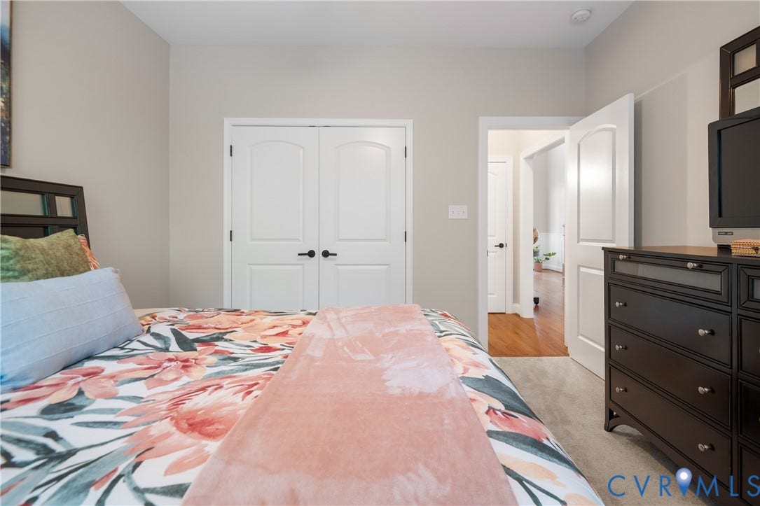 Neutral wall color, arched double doors, recessed lighting, and soft gray carpeting