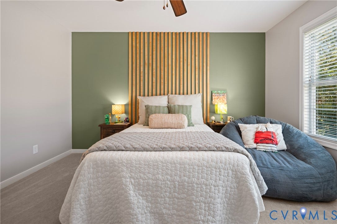 Room featuring carpet flooring, natural light from a window with horizontal blinds, and a ceiling fan