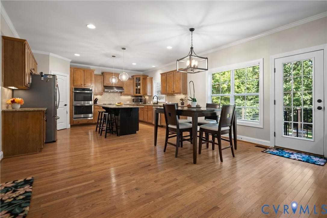 Kitchen featuring wood-finish flooring, recessed lighting, and a kitchen island with built-in seating