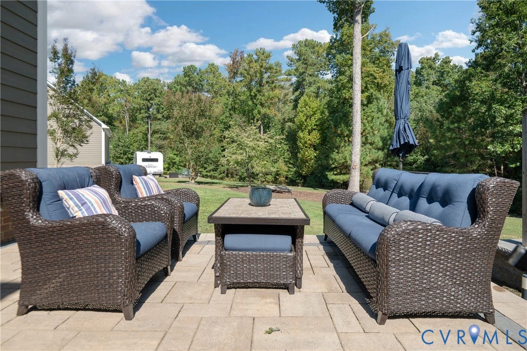 Paved patio with a natural stone-look surface and a wooded backdrop