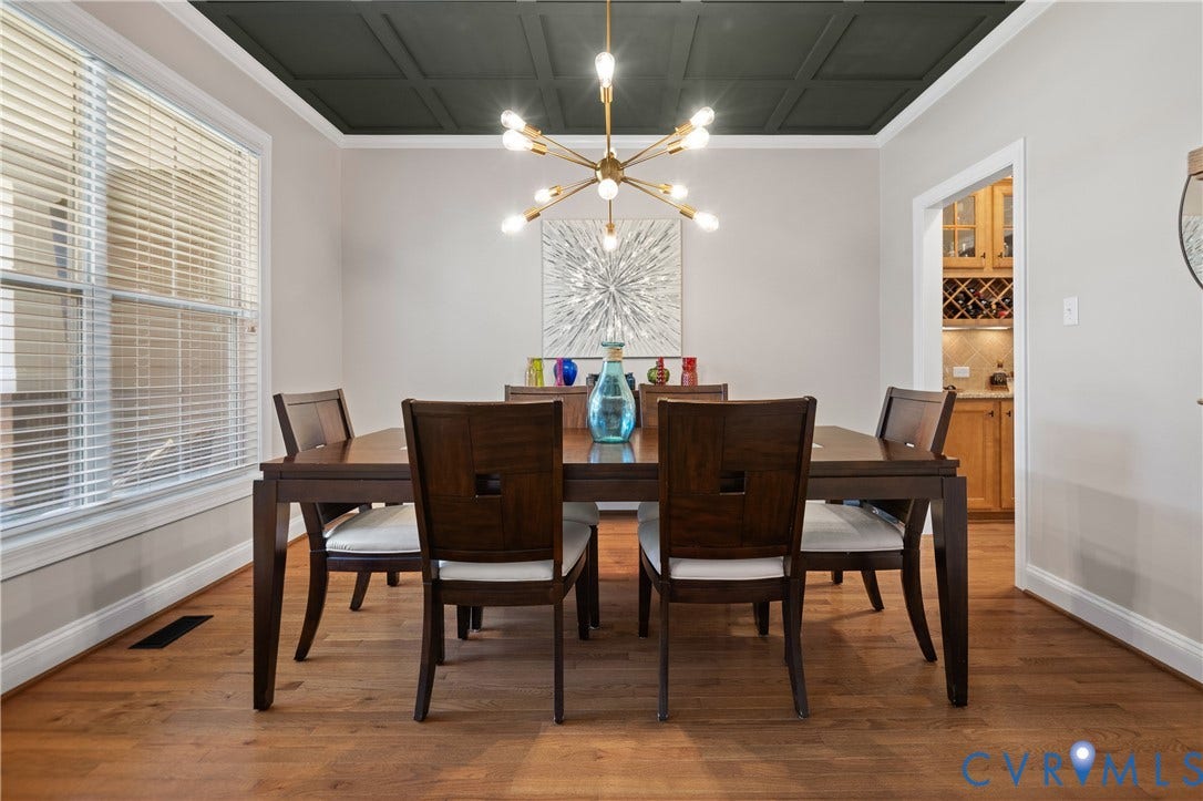 Hardwood flooring throughout, coffered ceiling, and modern chandelier