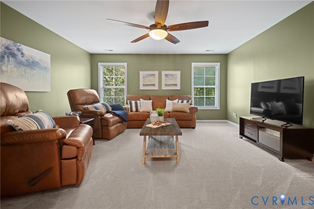 Carpeted flooring, two windows with blinds, a ceiling fan with integrated lighting, and painted walls