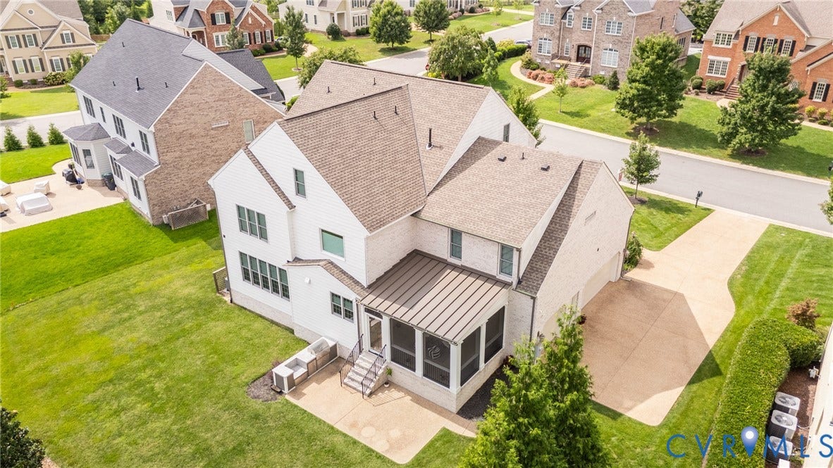 Aerial view of the back of the home with a large patio and outdoor kitchen space.