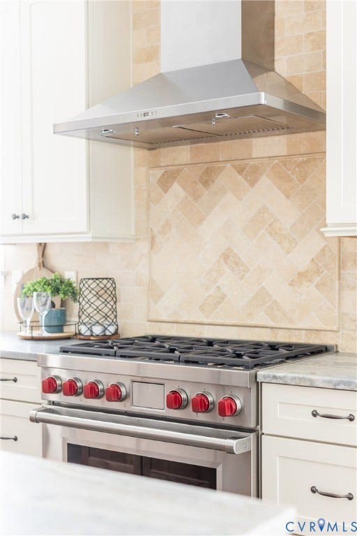 Stainless steel professional-grade WOLF range and hood, 36" gas cooktop, herringbone pattern tile and extra wide WOLF oven that holds 6 casserole dishes!