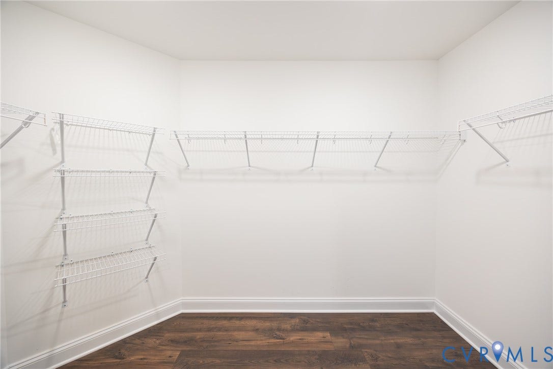 Large walk-in primary closet #1 featuring white wire shelving.