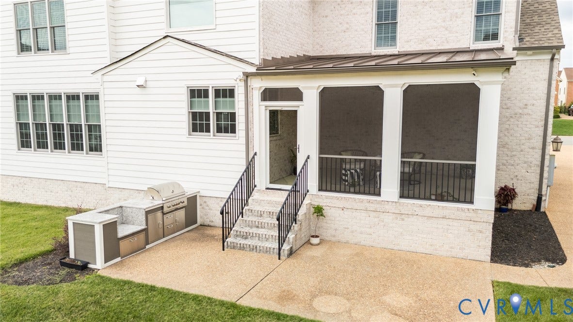 View of the great outdoor space including the built-in kitchen and screened porch.