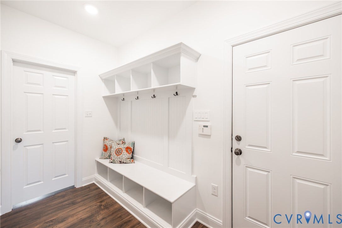 Mud room/drop zone with cubby style storage, hooks and access to the garage door as well as the office.