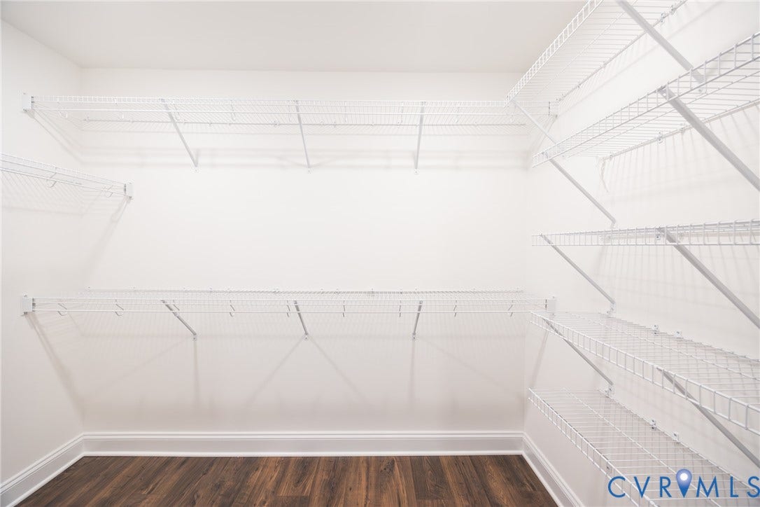 Large walk-in primary closet #2 featuring white wire shelving.