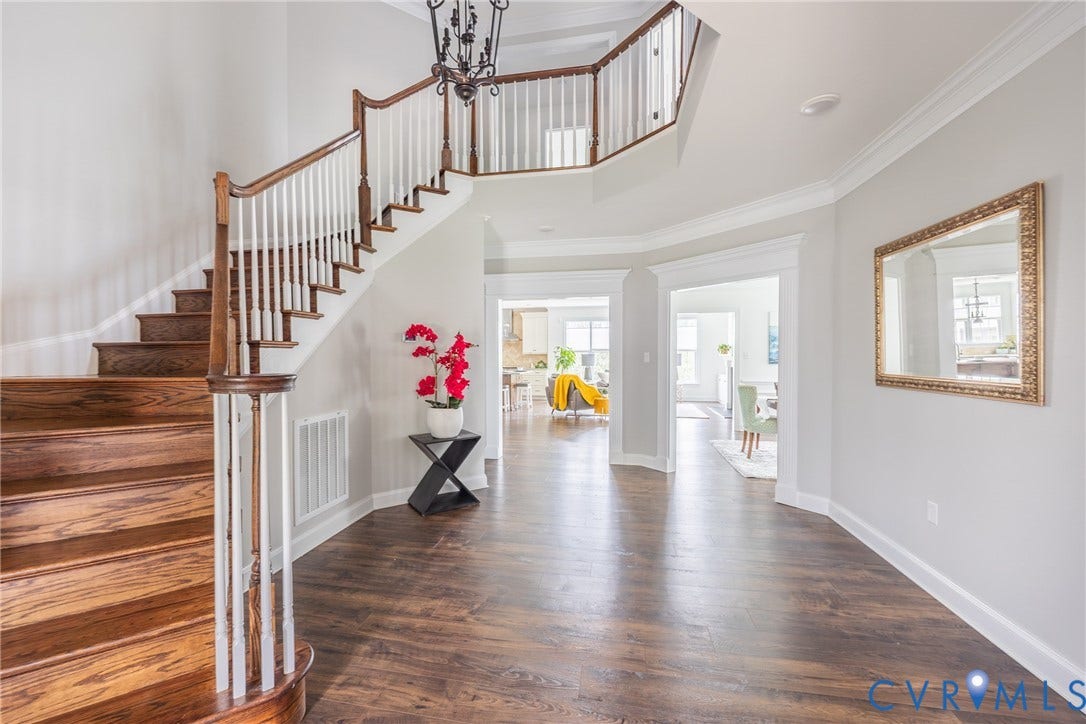 Open foyer with a wide hallway and curved staircase