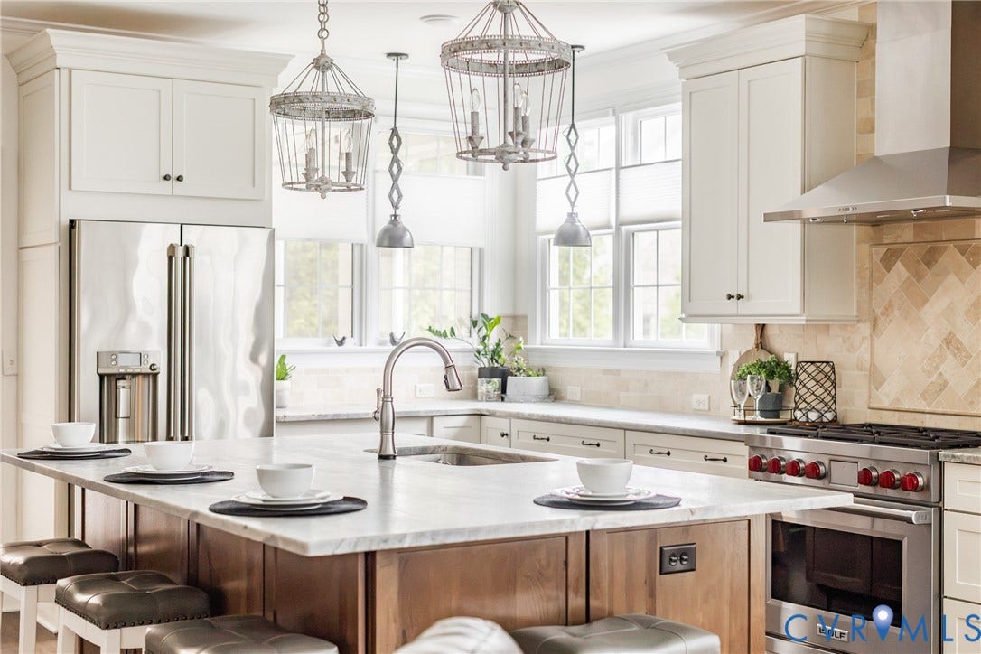 Leathered granite, Cafe refrigerator, WOLF oven with WOLF stainless steel range hood, and windows that allow for amazing light to enter the home.