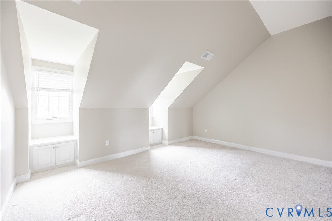 Bedroom five has sloped ceilings, dormer windows with bench seating and storage and a large closet.