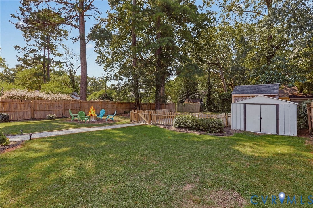 5108 Forest Hill Avenue, Westover Hills Area, Richmond, VA 23225 Expansive backyard featuring a lush lawn, privacy fencing, a dedicated fire pit area, a storage shed, and mature trees