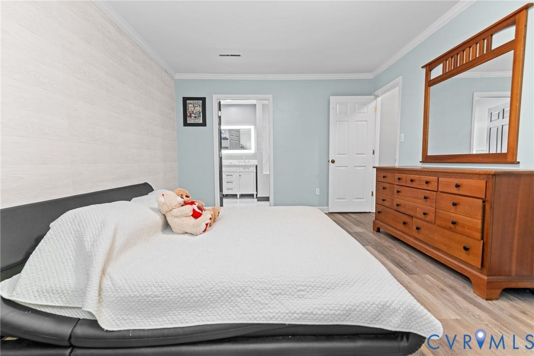 Wood-finish flooring with light blue wall paint and white crown molding
