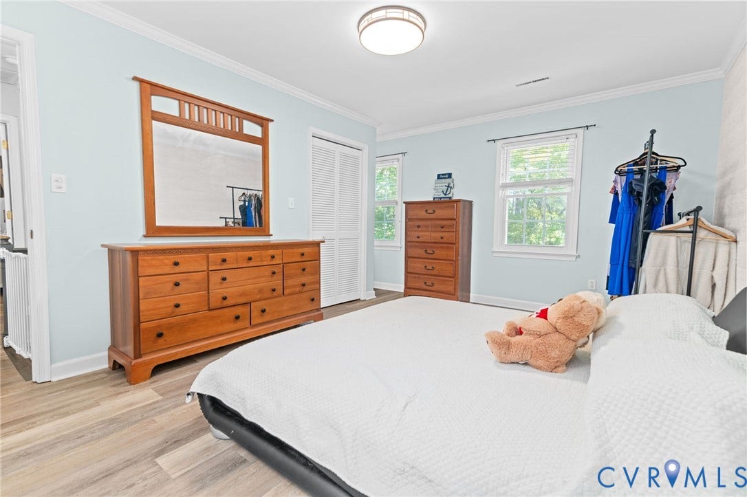 Wood-finish flooring, two windows with white trim, and a flush-mount ceiling light