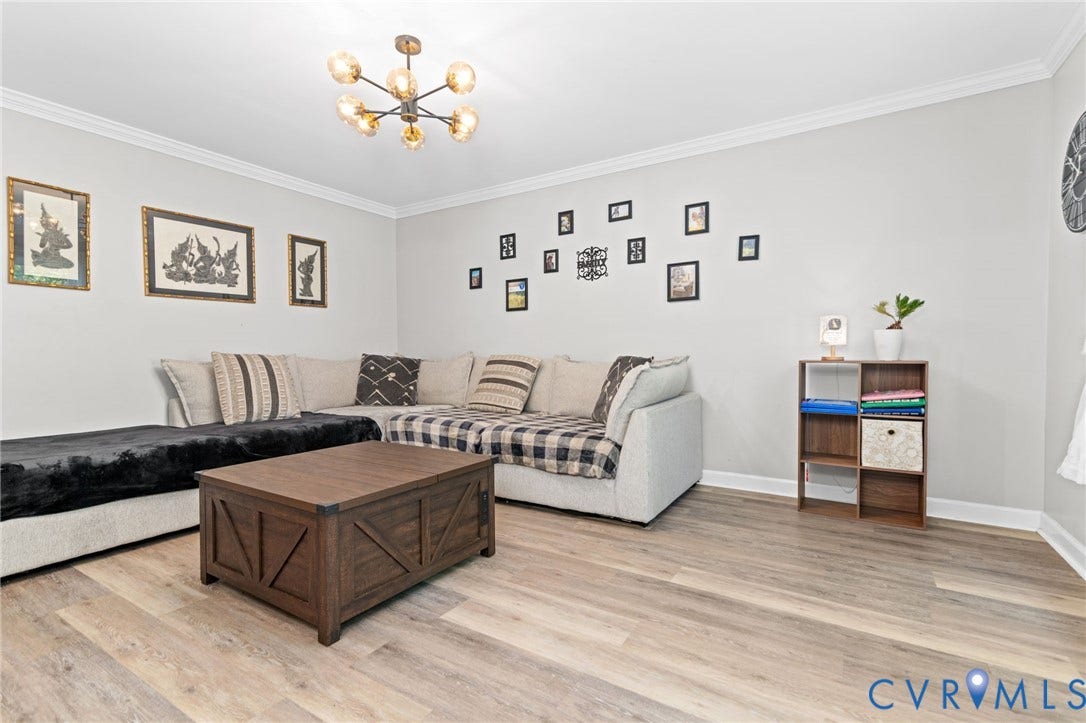 Wood-finish flooring, crown molding, and a contemporary ceiling fixture