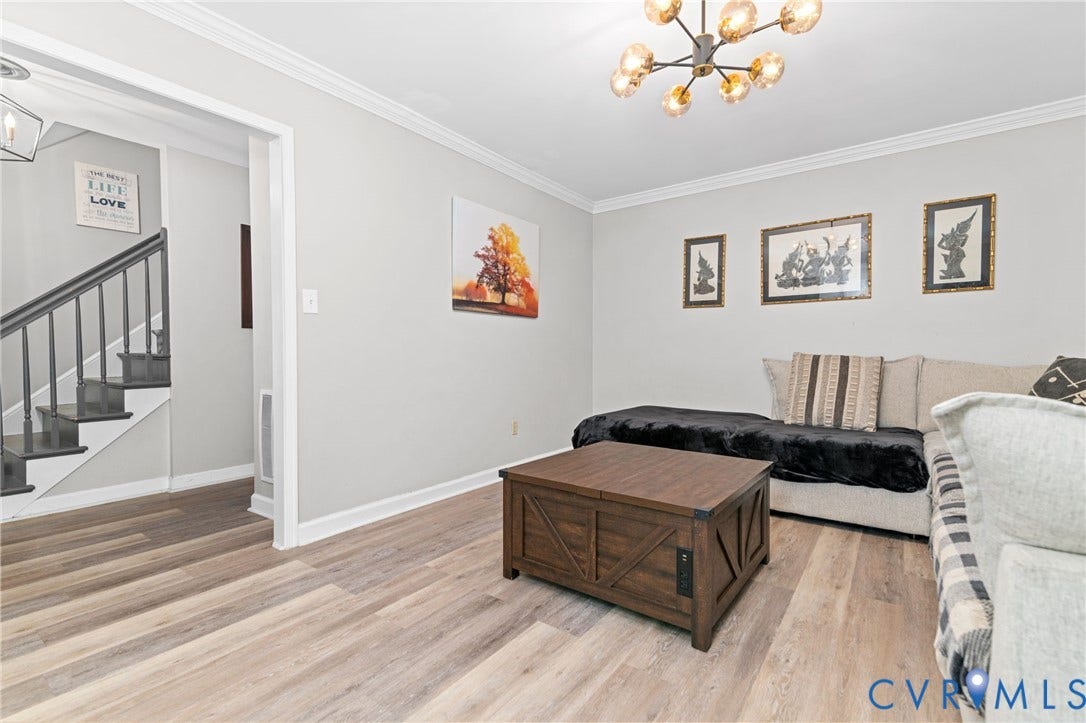 Neutral paint colors with white trim throughout, wood-finish flooring, and a contemporary ceiling fixture