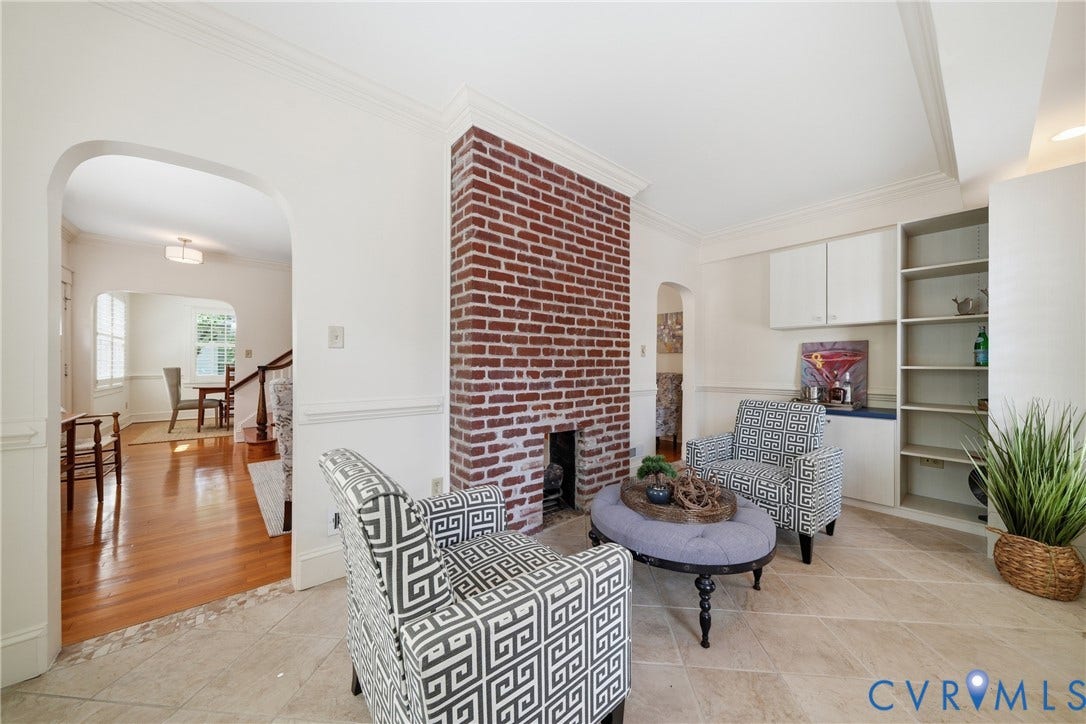 1500 Avondale Avenue, Bellevue, Richmond, VA 23227 Exposed brick fireplace with hearth, built-in shelving, arched doorway, and tile flooring