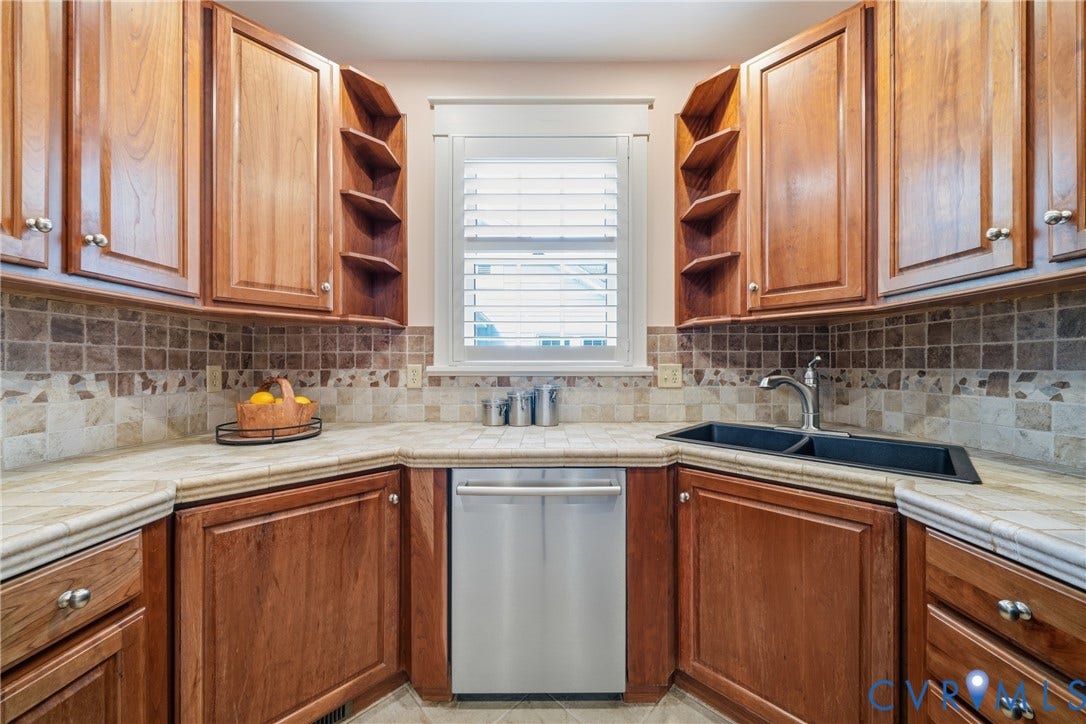 1500 Avondale Avenue, Bellevue, Richmond, VA 23227 Wood-finish cabinetry with silver hardware, stone tile countertops, and a mosaic tile backsplash