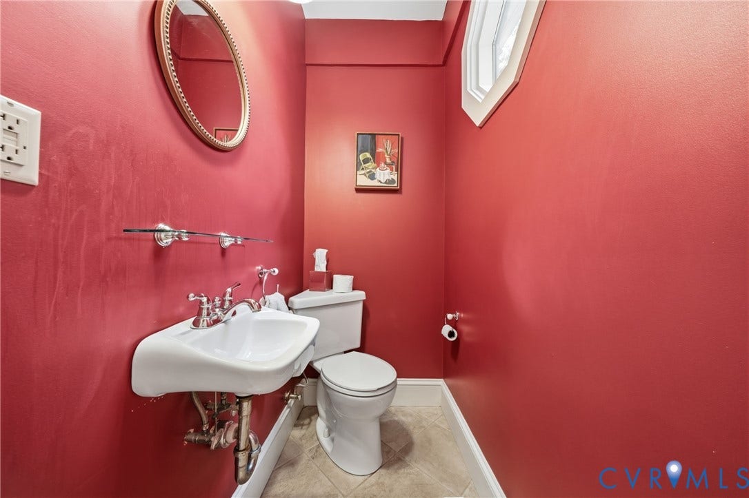 1500 Avondale Avenue, Bellevue, Richmond, VA 23227 Pedestal sink with chrome fixtures, an oval mirror with a decorative frame, and a white toilet