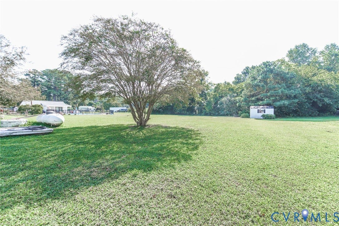 4912 Water View Road, Water View, Jamaica, VA 23180 Expansive green lawn featuring a mature deciduous tree and a white storage shed