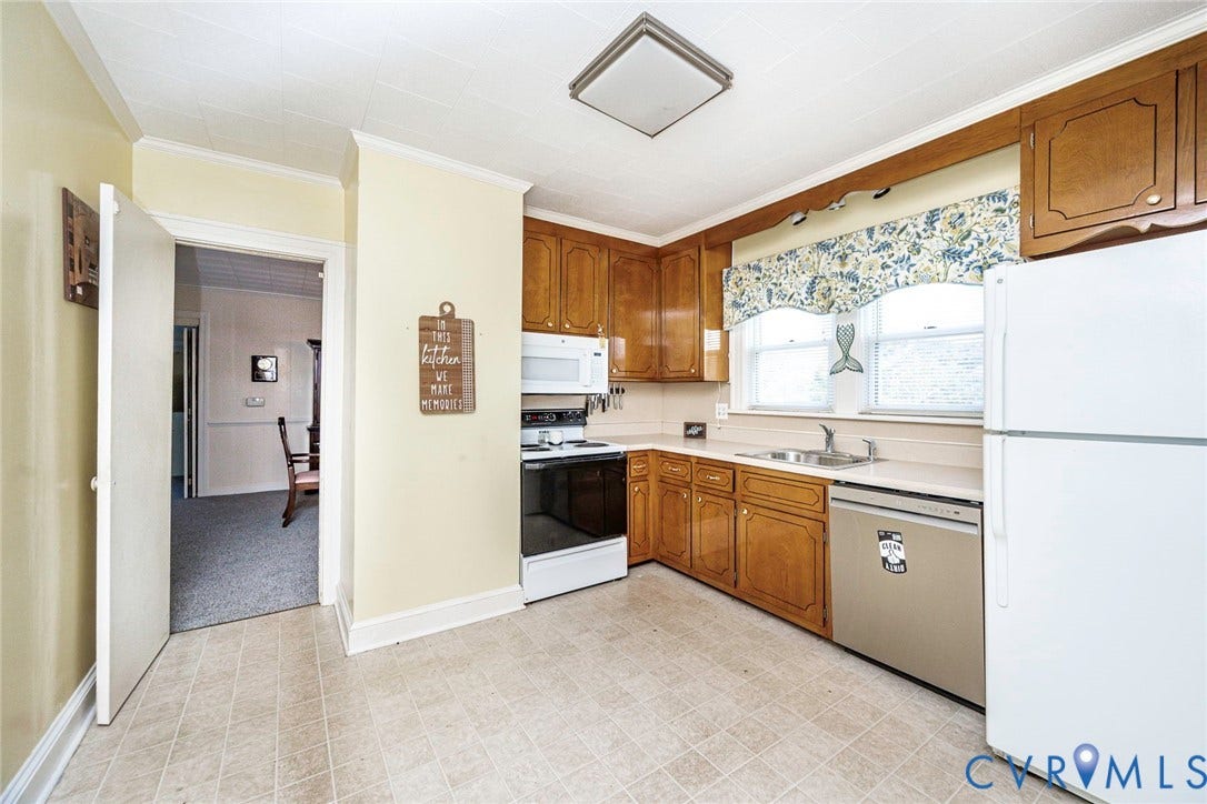 4912 Water View Road, Water View, Jamaica, VA 23180 Kitchen with wood cabinetry, light-toned countertops, and a stainless steel sink