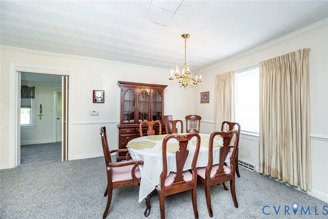 4912 Water View Road, Water View, Jamaica, VA 23180 Paneled walls with crown molding, gray carpeting, and a brass chandelier