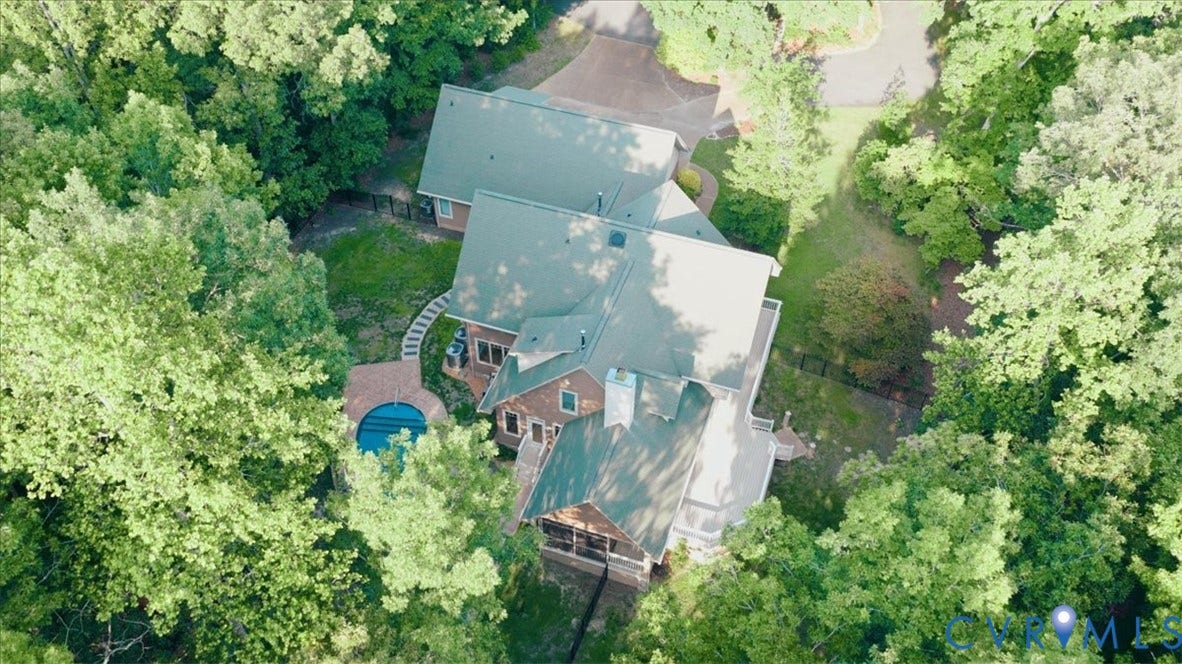 8908 Thomas Higgs Court, Toano, VA 23168 Expansive property featuring a multi-level structure, a circular pool with surrounding hardscaping, and a lush, tree-lined perimeter