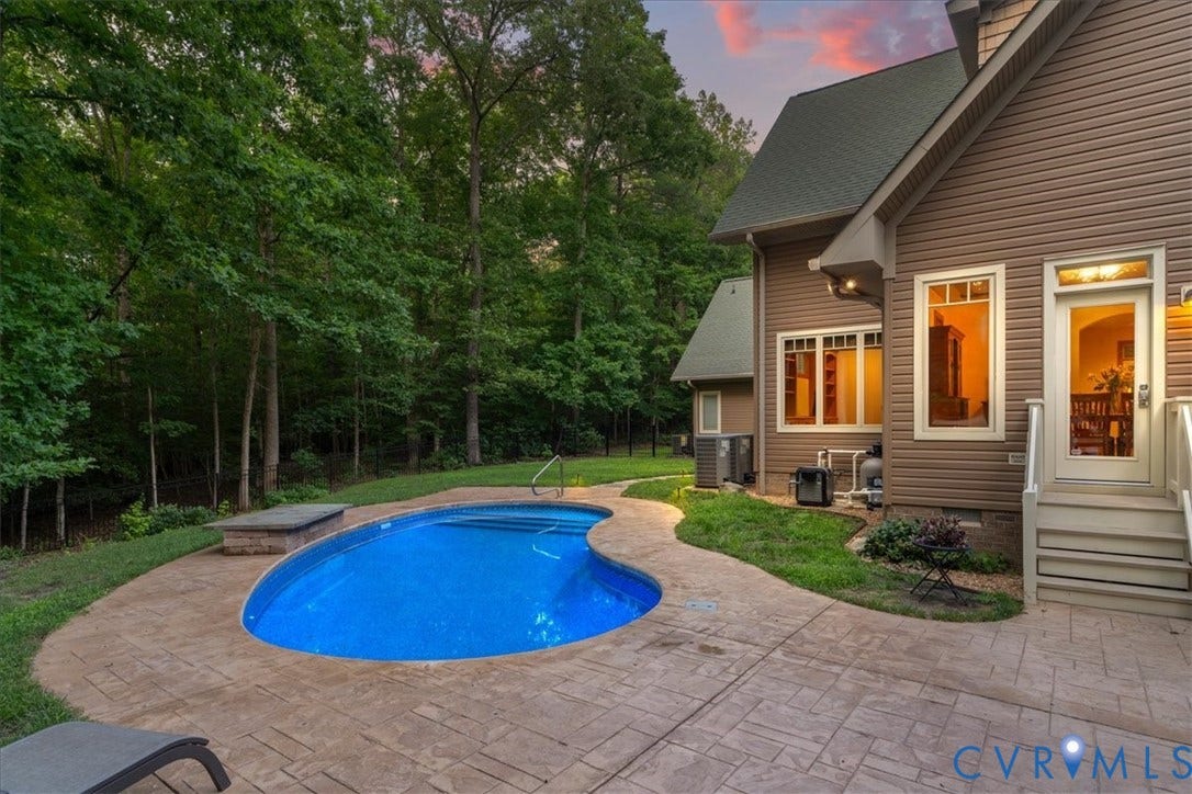 8908 Thomas Higgs Court, Toano, VA 23168 Exterior featuring a swimming pool, stamped concrete patio, and a stone-clad raised planter/ Heater pool