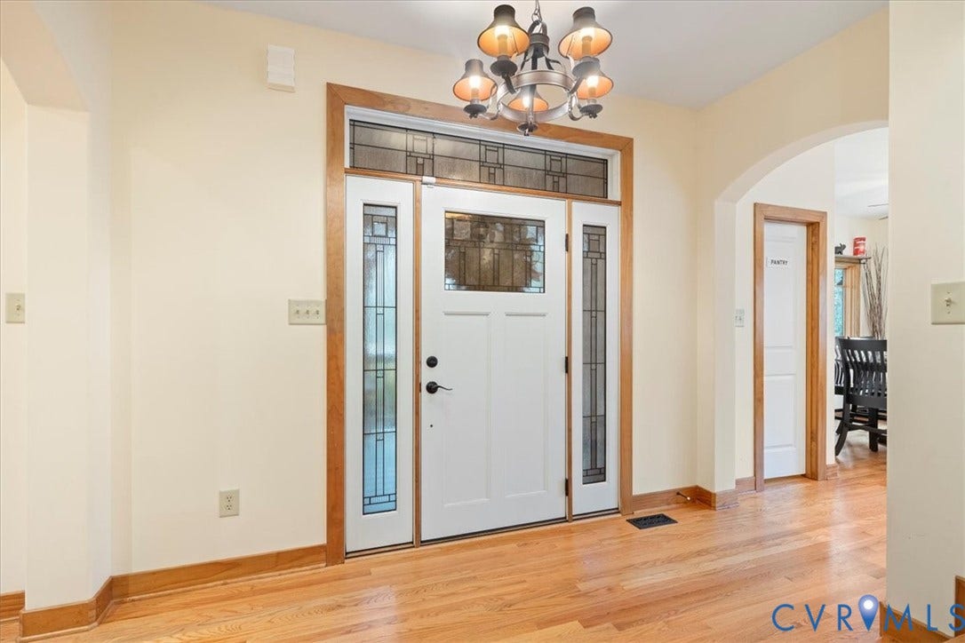 8908 Thomas Higgs Court, Toano, VA 23168 Entryway featuring a decorative transom, sidelight windows, a chandelier, hardwood flooring, and an arched doorway