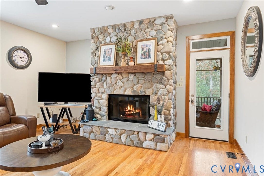 8908 Thomas Higgs Court, Toano, VA 23168 Stone-clad fireplace with a wood mantel, hardwood flooring, and recessed lighting