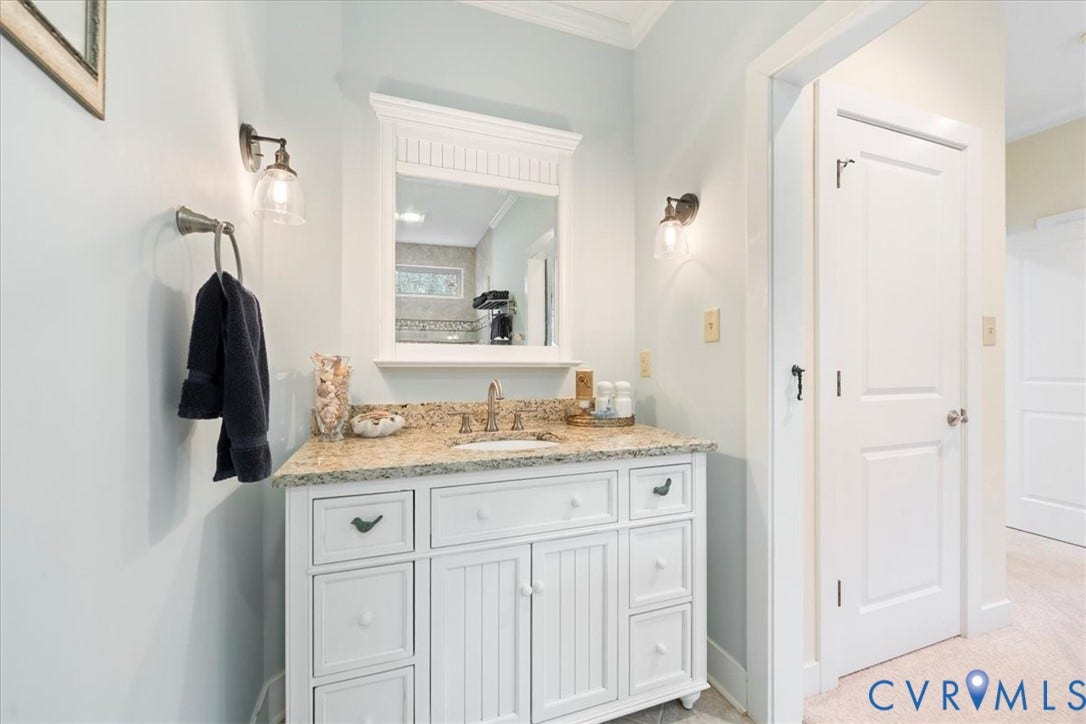 8908 Thomas Higgs Court, Toano, VA 23168 Vanity with a granite countertop, under-mount sink, and dual sconce lighting. Walk-in shower.
