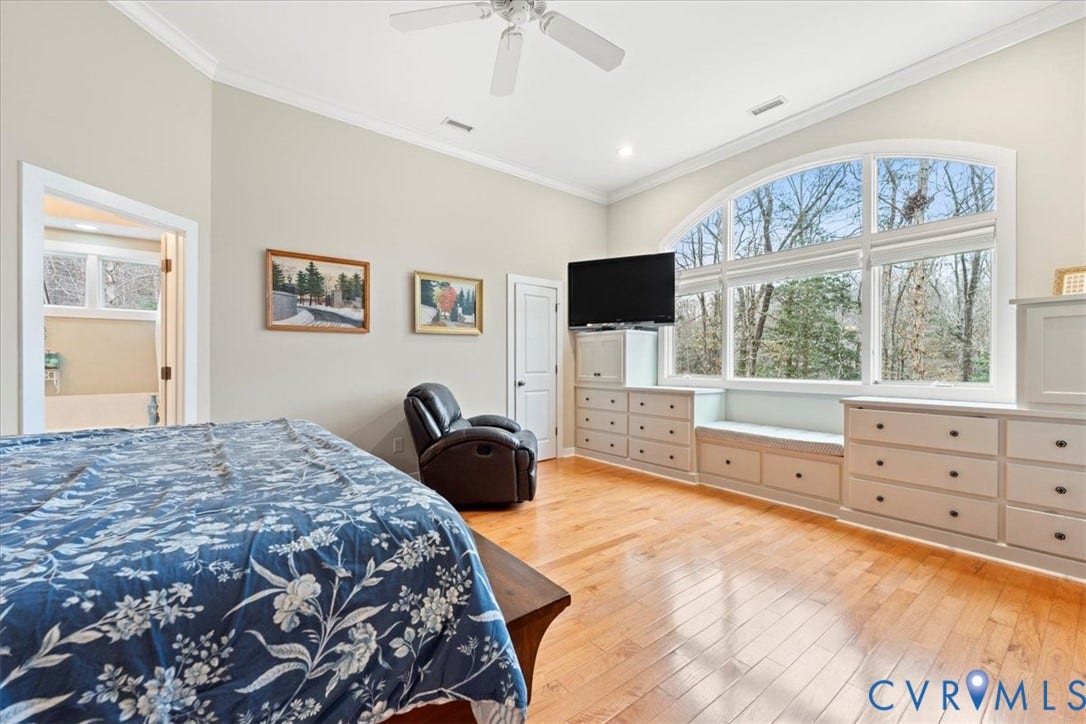 8908 Thomas Higgs Court, Toano, VA 23168 Hardwood flooring, arched window, built-in cabinetry, crown molding, and a ceiling fan