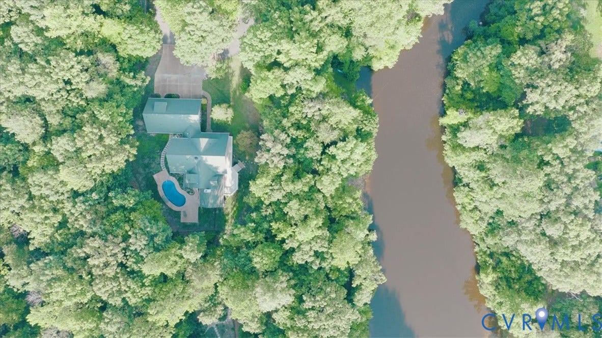 8908 Thomas Higgs Court, Toano, VA 23168 Property with a private pool, surrounded by mature trees, and an adjacent natural waterway