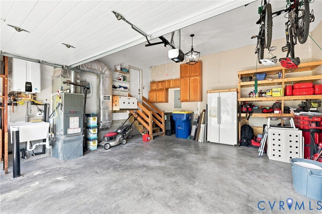 11342 McCauliff Court, North Chesterfield, VA 23236 Spacious garage featuring a utility sink, built-in cabinetry, and open shelving