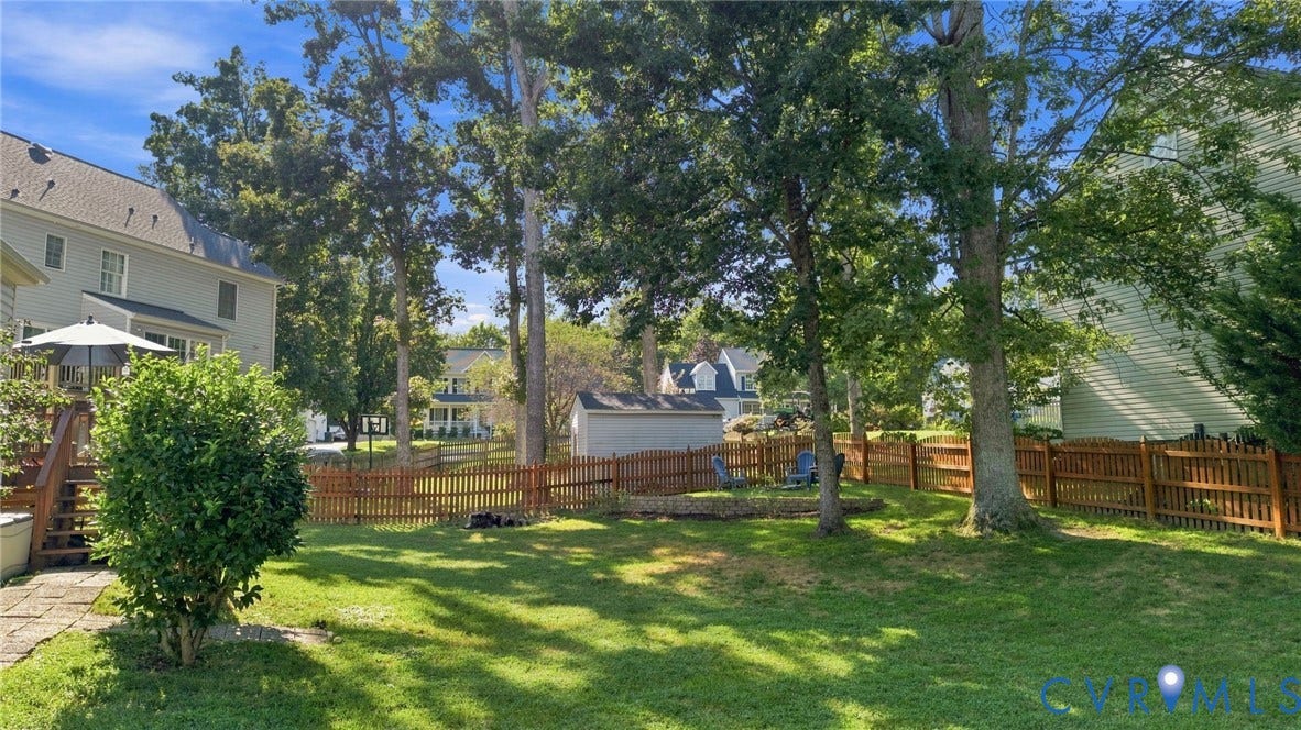 11342 McCauliff Court, North Chesterfield, VA 23236 Expansive backyard featuring a manicured lawn, mature trees, and a wooden picket fence