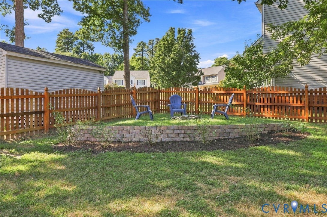11342 McCauliff Court, North Chesterfield, VA 23236 Expansive backyard featuring a wood fence, mature trees, and a brick retaining wall