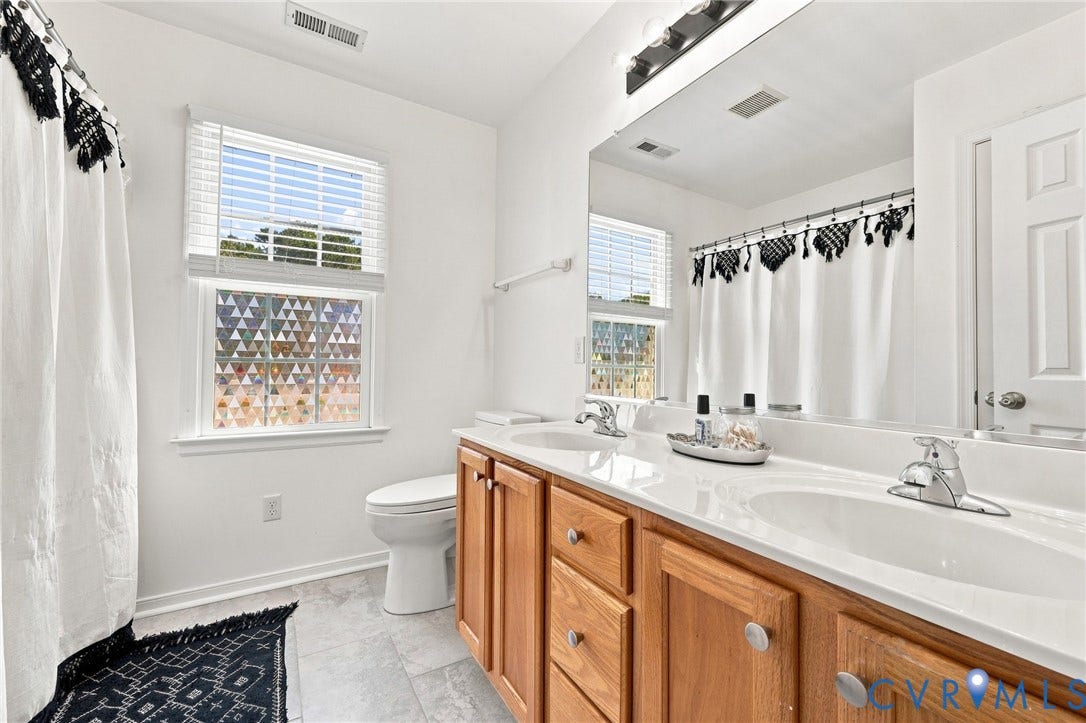 11342 McCauliff Court, North Chesterfield, VA 23236 Hall Bathroom w/ Double vanity with dual undermount sinks, wood-finish cabinetry, and a light-toned countertop