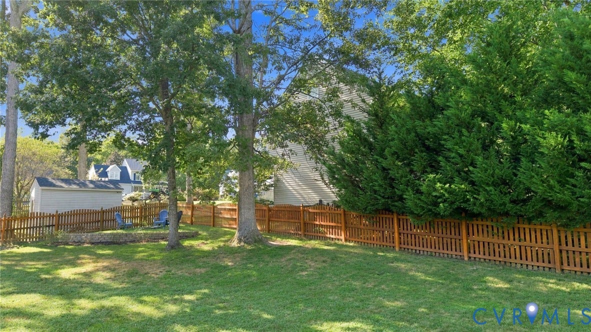 11342 McCauliff Court, North Chesterfield, VA 23236 Expansive grassy yard with mature trees, a wood privacy fence, and a storage shed