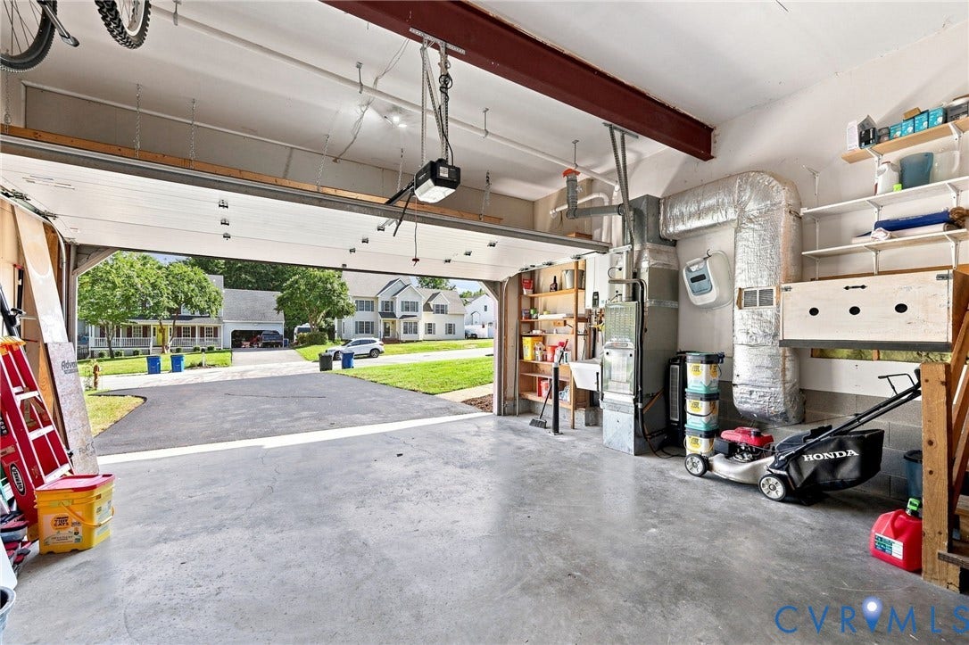 11342 McCauliff Court, North Chesterfield, VA 23236 Spacious garage with an automatic overhead door, concrete flooring, and built-in shelving
