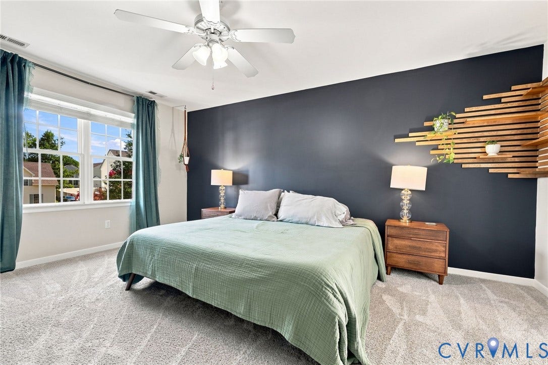 11342 McCauliff Court, North Chesterfield, VA 23236 White ceiling fan with integrated lighting, large window with white trim, dark accent wall, and light-toned carpet