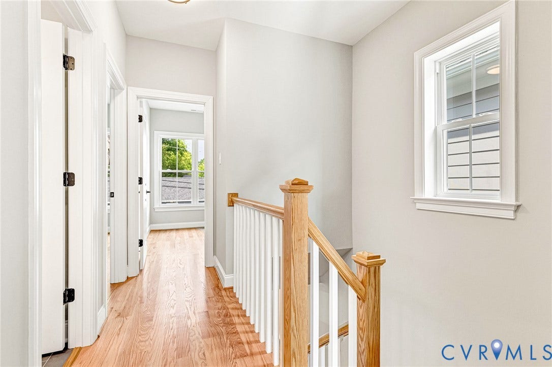 310 E 33rd Street, Swansboro West, Richmond, VA 23224 Hardwood flooring, painted interior walls, white trim, wood staircase newel post and handrail, and a double-hung window