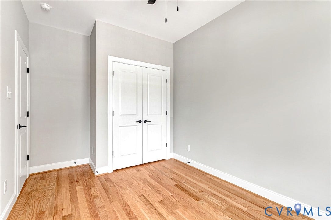 310 E 33rd Street, Swansboro West, Richmond, VA 23224 Bright bedroom showcasing gleaming wood-finish flooring, crisp white walls, and ample natural light from multiple windows