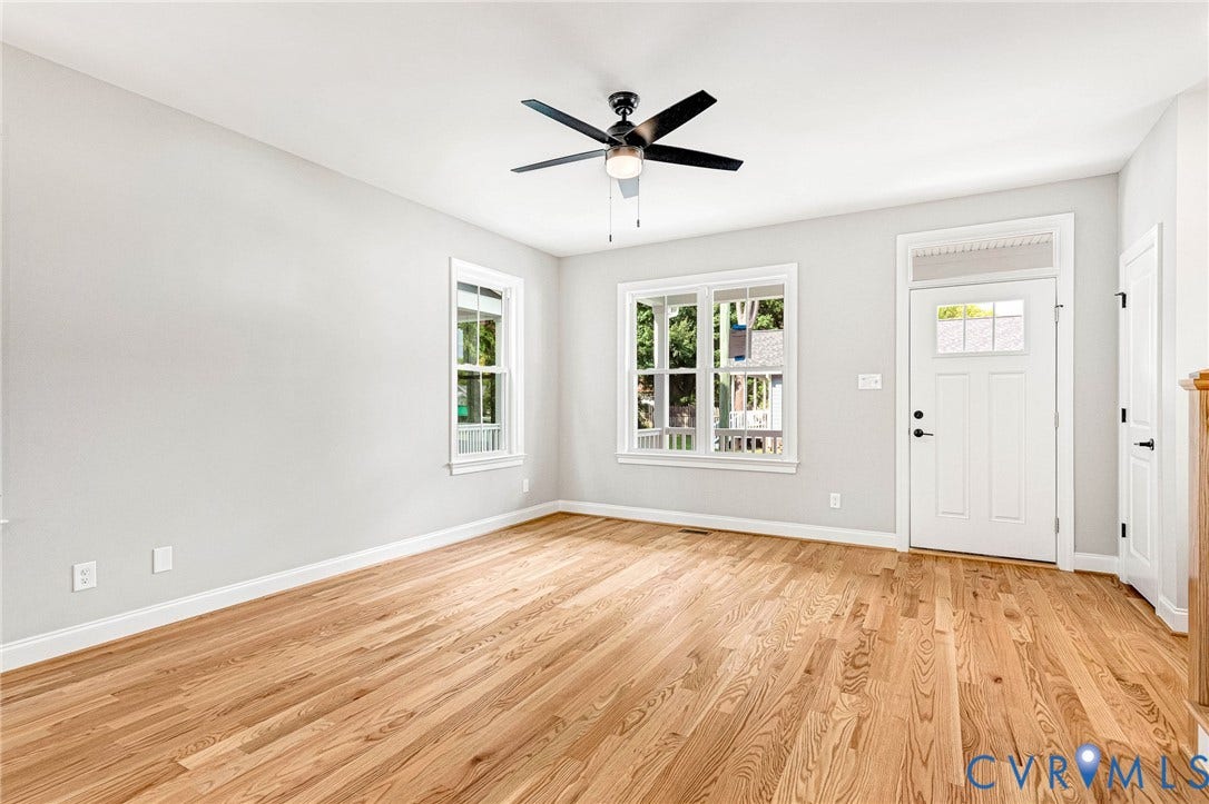310 E 33rd Street, Swansboro West, Richmond, VA 23224 Hardwood flooring, painted walls, ceiling fan with light fixture, multiple windows, and a white entry door with transom window